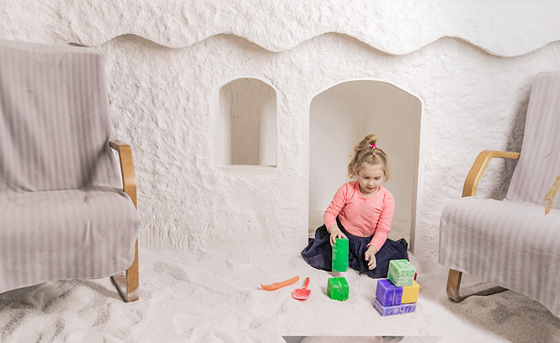 Little girl playing with toys in a salt cave at Salt Room Winter Haven in FL